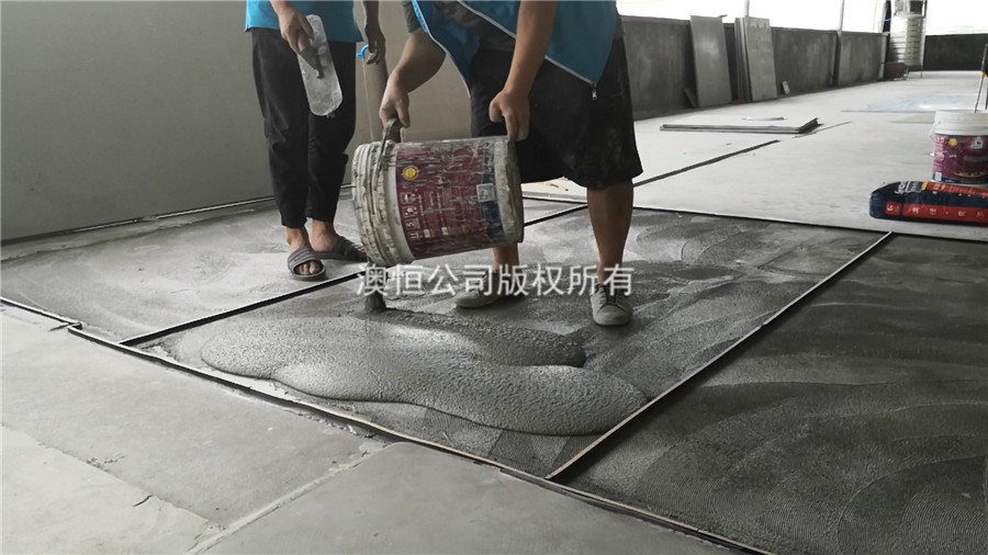 將攪拌后的無(wú)機(jī)磨石材料傾倒在地面上